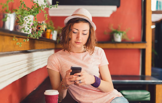 Young woman using her mobile phone in a cafe